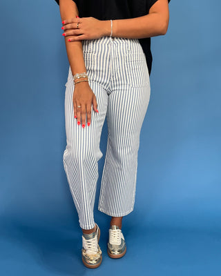 Person wearing white striped pants on a blue background