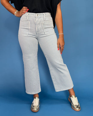 Person wearing white and blue striped pants on a blue background