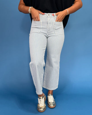 Person wearing white and blue striped pants on a blue background