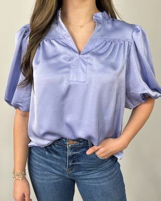 Soft, sleek, and effortlessly chic 💙 This silky lavender blouse features a flattering notched neckline and statement puff sleeves that instantly elevate your everyday denim—perfect for work, dinner, or anything in between!
