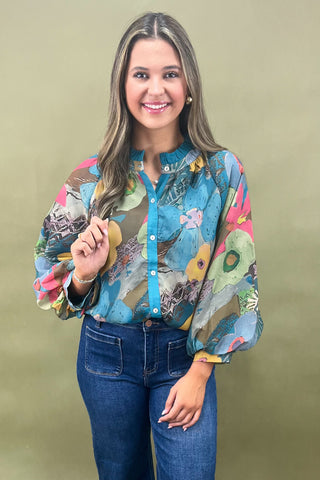 Woman wearing a colorful patterned shirt against a plain background