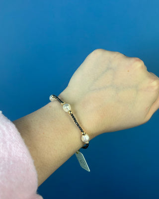 Shop the Purpose Admire Pearl 8mm Hematite Bracelet by enewton, featuring dark hematite beads, white pearl accents, and elegant gold-tone details.