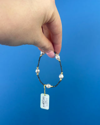 Shop the Purpose Admire Pearl 8mm Hematite Bracelet by enewton, featuring dark hematite beads, white pearl accents, and elegant gold-tone details.