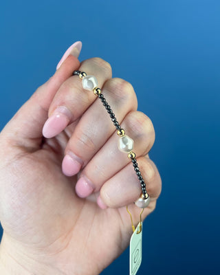 Shop the Purpose Admire Pearl 8mm Hematite Bracelet by enewton, featuring dark hematite beads, white pearl accents, and elegant gold-tone details.