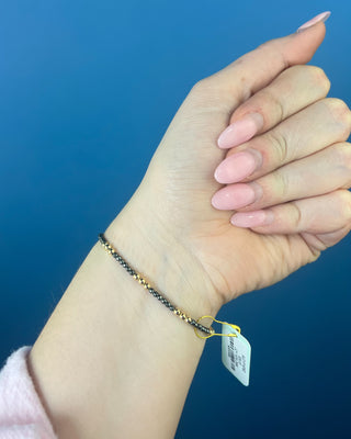 Shop the Joy Hematite 2mm Bracelet by enewton, featuring delicate dark hematite beads and polished gold accents. Perfect for everyday wear and layering.