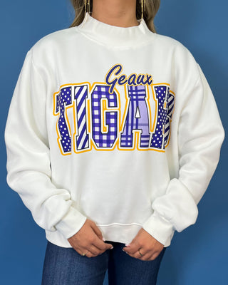 White Geaux Tigers graphic sweatshirt with bold purple mixed-print lettering, gold accents, mock neckline, long sleeves, and a relaxed fit.