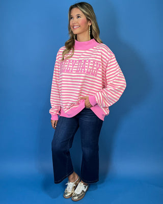 Pink and cream striped Dolly Dally graphic sweatshirt with a mock neckline, long sleeves, contrast pink trim, and relaxed oversized fit.