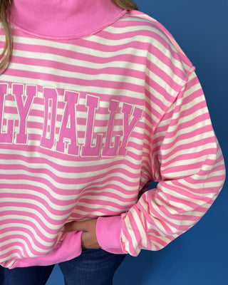 Pink and cream striped Dolly Dally graphic sweatshirt with a mock neckline, long sleeves, contrast pink trim, and relaxed oversized fit.
