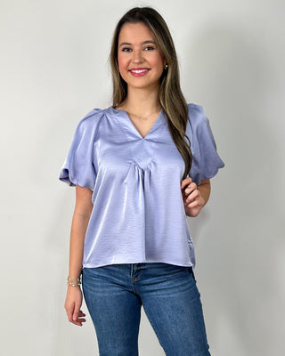 Soft and breezy in the prettiest periwinkle shade 💜 This flutter-sleeve blouse features a flattering v-neck with gentle pleating for that easy, flowy fit we love—perfect with your favorite denim and a simple heel for an effortlessly polished look.