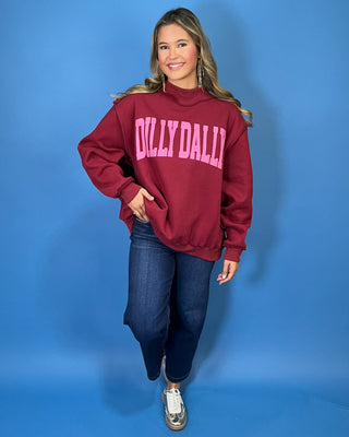 Burgundy Dilly Dally graphic sweatshirt with bold pink lettering, mock neckline, long sleeves, ribbed trim, and a relaxed oversized fit.