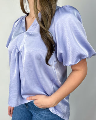 Soft and breezy in the prettiest periwinkle shade 💜 This flutter-sleeve blouse features a flattering v-neck with gentle pleating for that easy, flowy fit we love—perfect with your favorite denim and a simple heel for an effortlessly polished look.