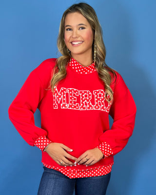 Red Merry graphic sweatshirt with white polka dot lettering, coordinating polka dot mock neckline, cuffs and hem, long sleeves, and a relaxed fit.