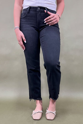 Person wearing black jeans and a white top on a plain background