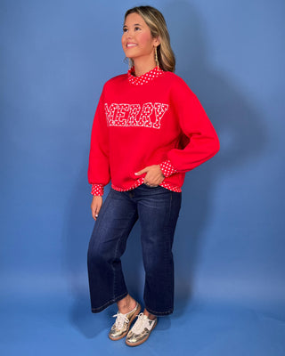 Red Merry graphic sweatshirt with white polka dot lettering, coordinating polka dot mock neckline, cuffs and hem, long sleeves, and a relaxed fit.