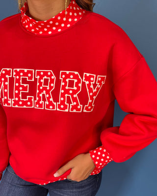 Red Merry graphic sweatshirt with white polka dot lettering, coordinating polka dot mock neckline, cuffs and hem, long sleeves, and a relaxed fit.