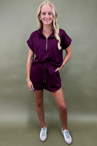 Woman wearing a purple outfit with a plain background