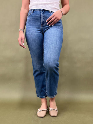 Person wearing blue jeans on a plain background