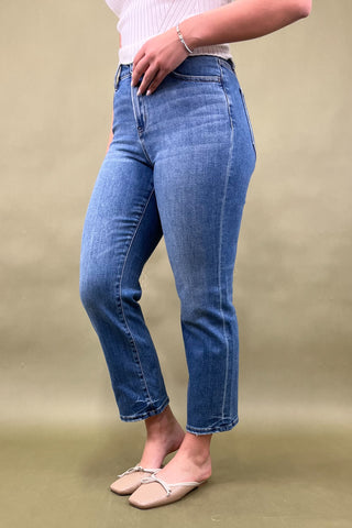 Person wearing blue jeans on a beige background