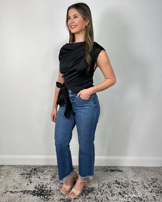 Chic black satin tie-front top with a softly draped neckline, paired with raw-hem flare jeans and nude block heels for that effortlessly elevated look. It’s the perfect mix of sleek + comfortable—easy for date night, dinner plans, or whenever you want to feel a little extra polished.