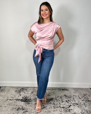 Blush satin tie-front top with a soft draped neckline, styled with cropped raw-hem flare jeans and nude block heels for an easy dressy-casual look. Perfect for date night, brunch, or any event where you want to feel polished without trying too hard.