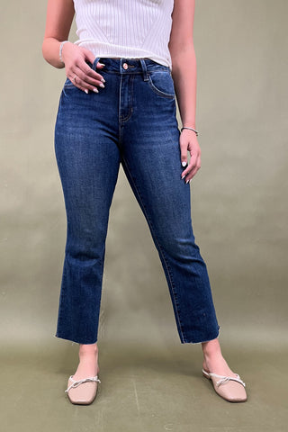 Person wearing blue jeans and a white top on a plain background