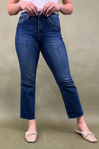 Person wearing blue jeans on a plain background