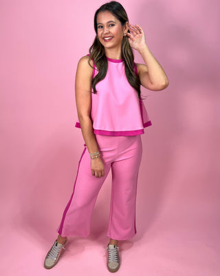 Woman wearing a pink outfit against a pink background