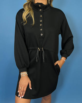 Black long sleeve mini dress with a buttoned mock neckline, adjustable drawstring waist, side pockets, and an easy sporty-chic silhouette.