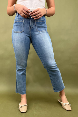 Person wearing blue jeans on a green background