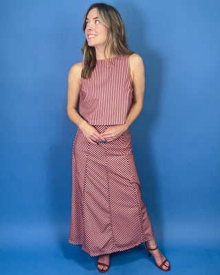 Burgundy and blush striped two-piece set featuring a sleeveless cropped top and coordinating high-waisted maxi skirt with mixed-direction stripe detailing.