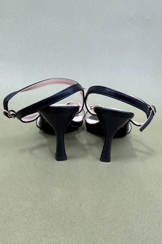 Black high-heeled shoes on a light gray background