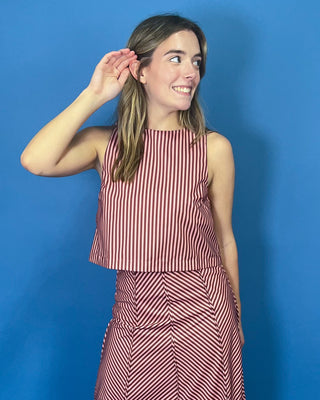 Burgundy and blush striped two-piece set featuring a sleeveless cropped top and coordinating high-waisted maxi skirt with mixed-direction stripe detailing.