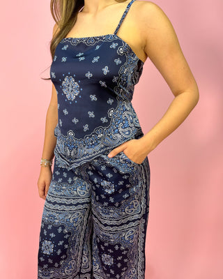 Woman wearing a blue paisley dress against a pink background