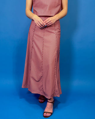 Burgundy and blush striped two-piece set featuring a sleeveless cropped top and coordinating high-waisted maxi skirt with mixed-direction stripe detailing.