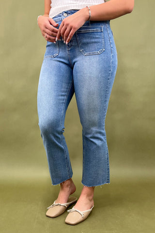 Person wearing blue jeans on a green background