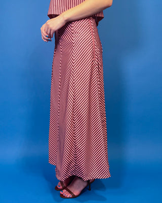 Burgundy and blush striped two-piece set featuring a sleeveless cropped top and coordinating high-waisted maxi skirt with mixed-direction stripe detailing.