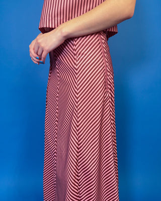 Burgundy and blush striped two-piece set featuring a sleeveless cropped top and coordinating high-waisted maxi skirt with mixed-direction stripe detailing.