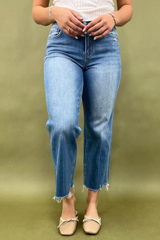 Person wearing blue jeans on a green background