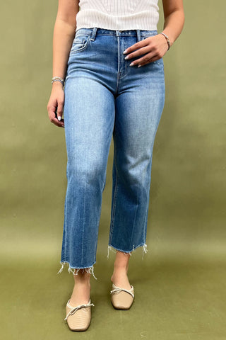 Person wearing blue jeans on a green background