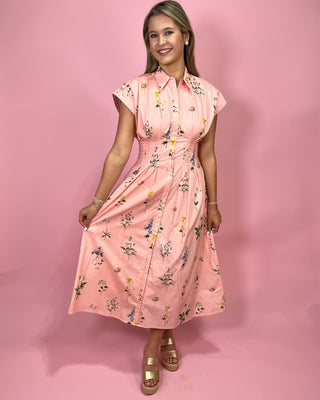 Woman wearing a pink floral dress against a pink background