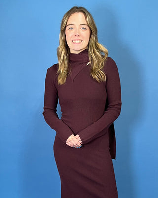 Deep burgundy ribbed knit maxi dress with long sleeves, a fitted silhouette, side slit, and chic asymmetrical cutout mock neckline.