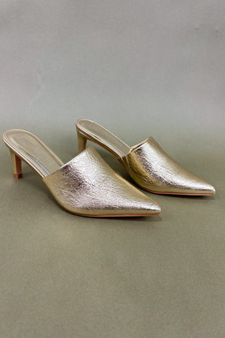 Pair of gold high-heeled shoes on a gray background