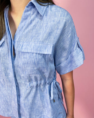 Blue checkered dress worn by a person on a pink background