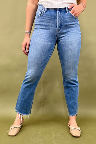 Person wearing blue jeans on a green background