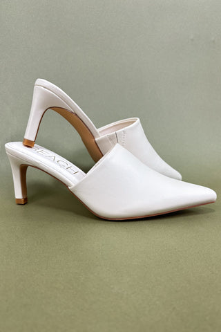 White high-heeled shoes on a green background