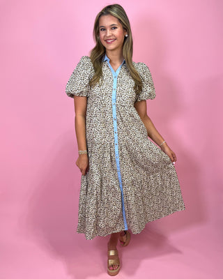 Woman wearing a patterned dress with a pink background