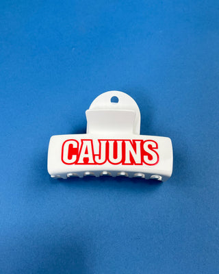 White oversized Cajuns claw hair clip with bold red lettering, durable spring hinge, and strong grip teeth for secure everyday styling.