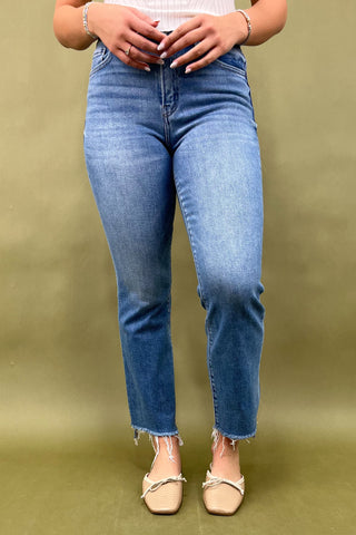 Person wearing blue jeans on a green background