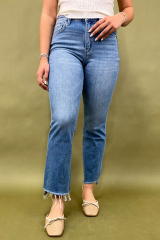 Person wearing blue jeans on a green background