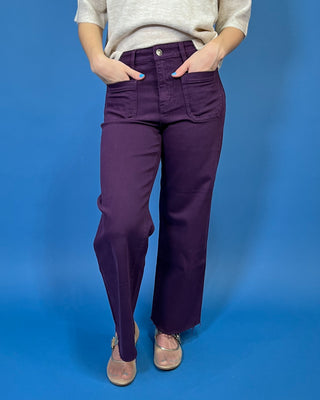 Deep purple high-rise wide leg jeans with front patch pockets, a flattering structured fit, and trendy raw hem detailing.